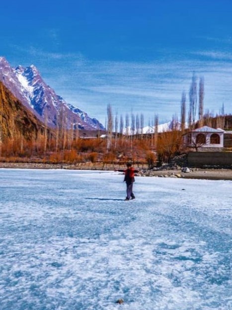 A person walking on frozen Khalti Lake